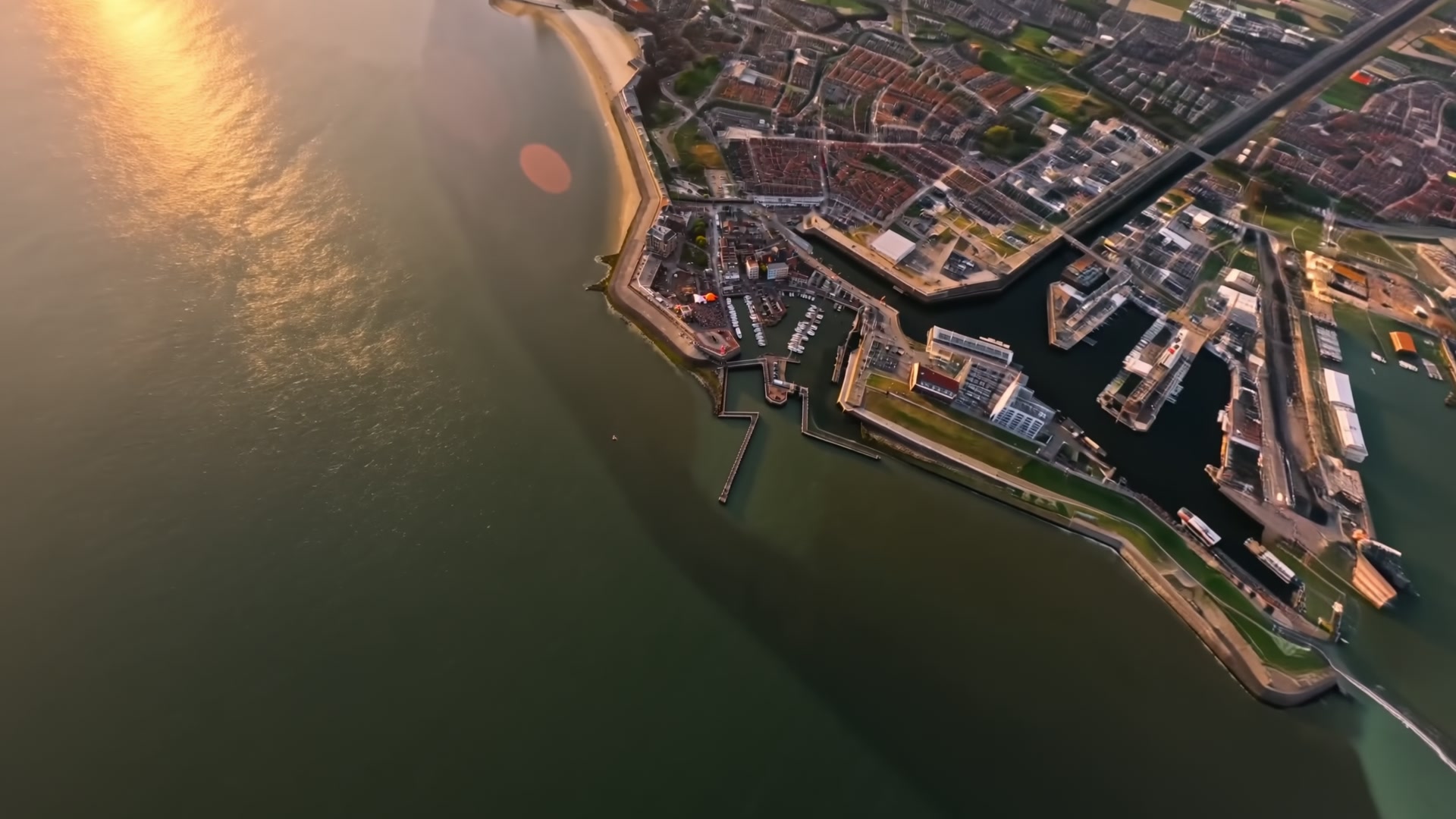 De kust van Vlissingen vanuit de lucht, met de haven en de Westerschelde in het late licht.